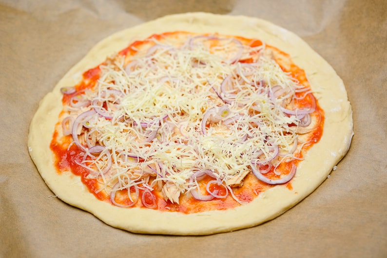 Place cheese on top of the tuna pizza.