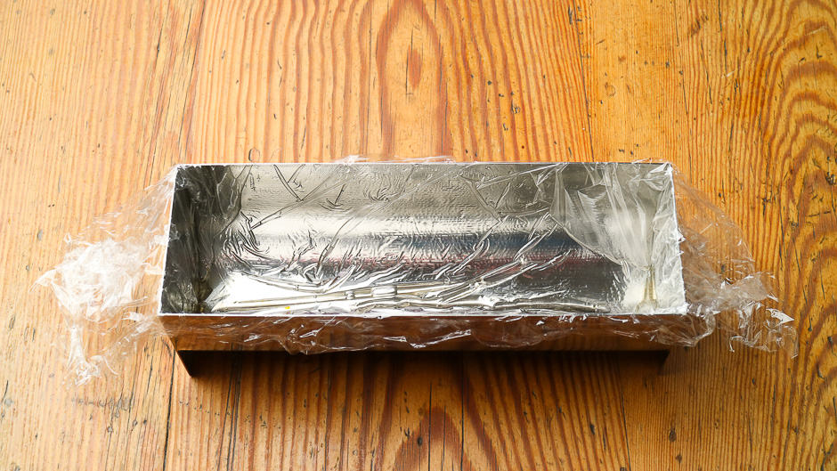 Loaf pan lined with cling film.