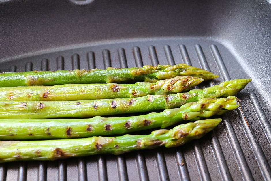 Grilling green asparagus in the pan.