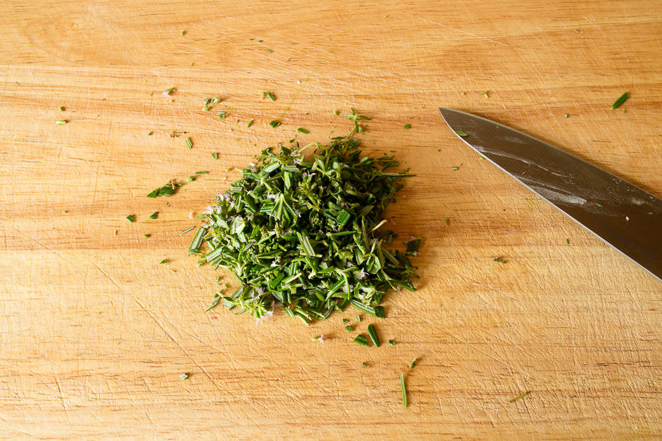Finely chopped herbs on cutting board.