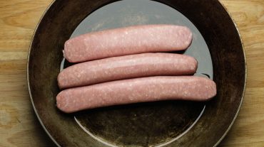 Fresh raw sausages in the pan