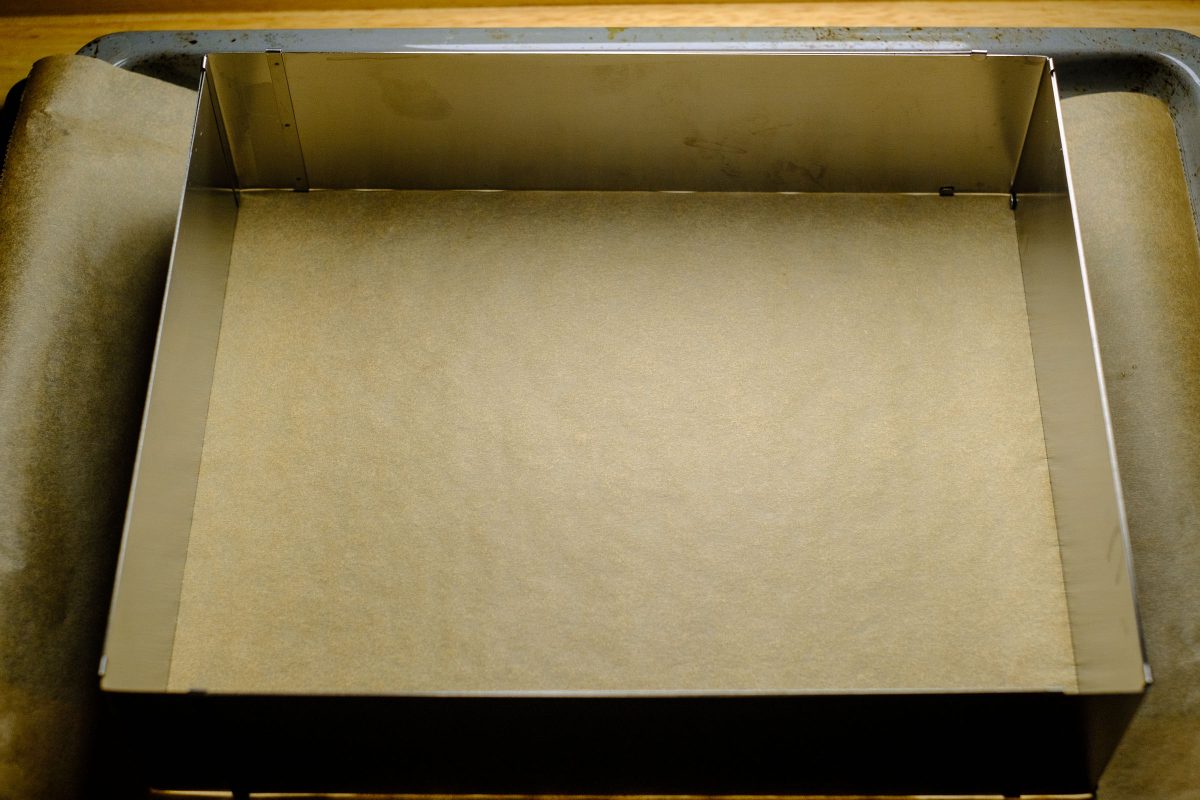 Baking tray with cake tin and parchment paper