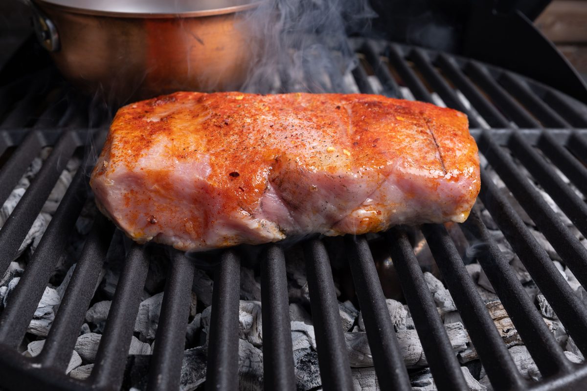 Sear grill raw pork loin. Close-up on the grill grate