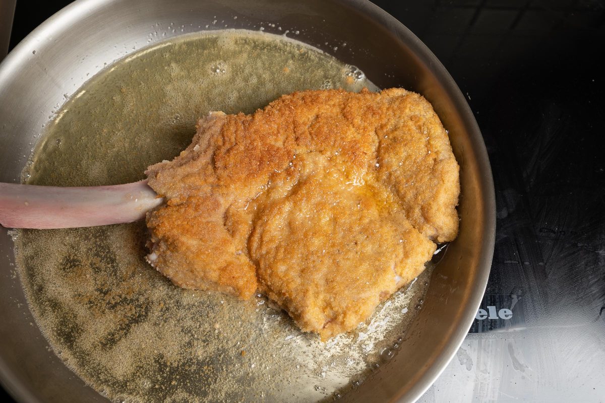 Breaded veal cutlet, Cotoletta Milanese, turned in the pan